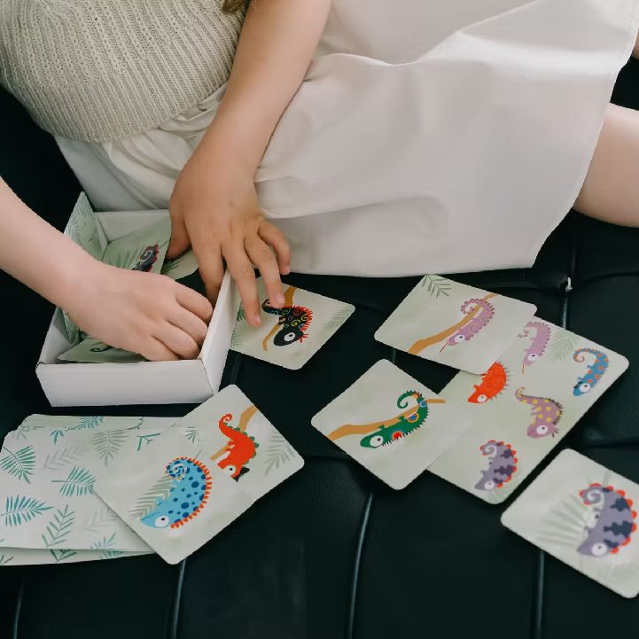 A child sorting colorful chameleon matching cards during a play therapy session